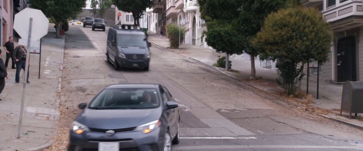 SUVs chasing van down a hilly San Francisco street.