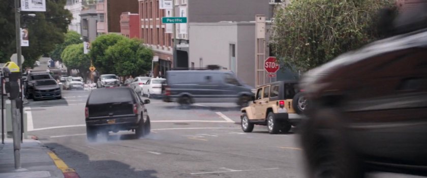 SUV chasing van around corner on San Francisco street.