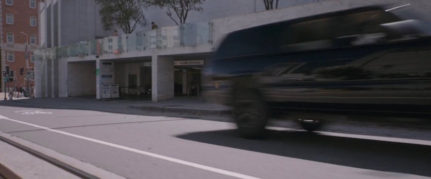 SUV racing by building on San Francisco street.