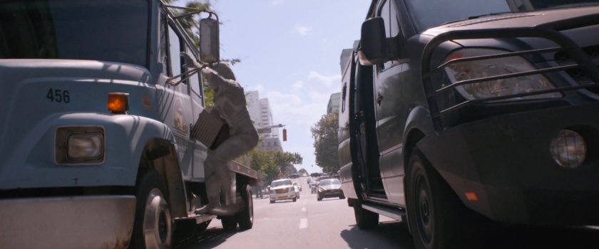 The Ghost on a side of flatbed truck with van speeding next to it.