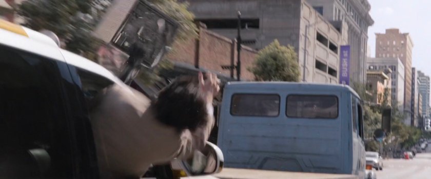 Sonny grabbing the miniature lab from a following SUV.