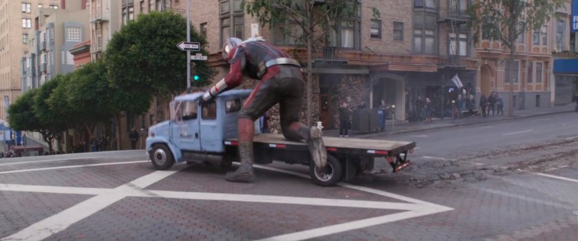 Giant-Man hops on back of flatbed truck like a scooter.