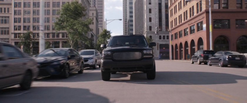 Black SUV speeding on a street.