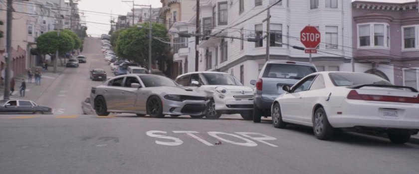 Two pursuit cars crash into parked cars.