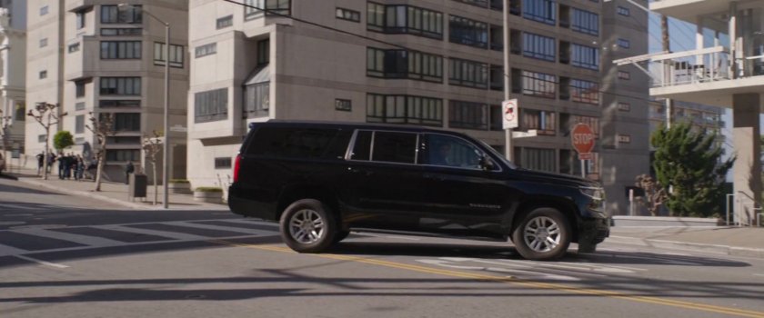 A black SUV stops in an intersection.