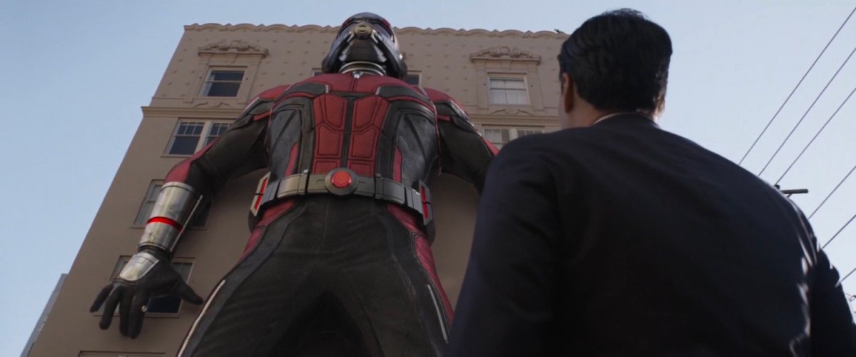 Agent Woo looks up at the Giant-Man costume beside a building.