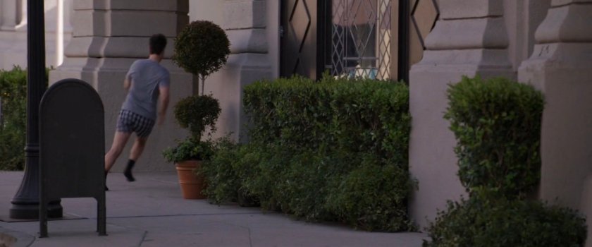 Scott Lang runs around a corner of a building.