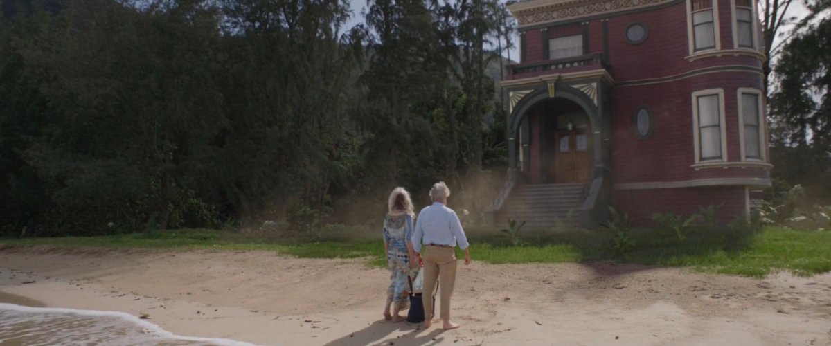 Janet and Hank stand on a beach in front of the Pym House.