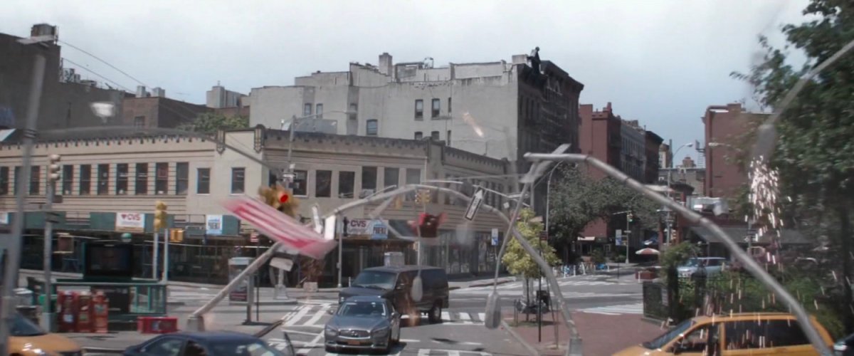 Light poles bending towards Spider-Man as he dodges them near a New York intersection.