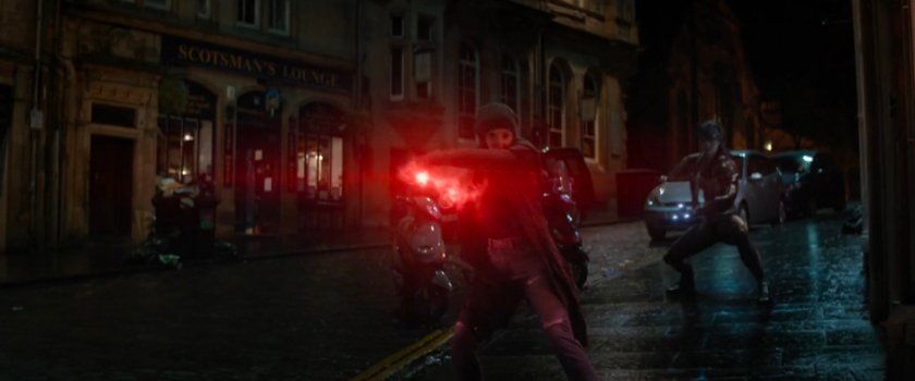 Wanda casting a spell on a dark street.