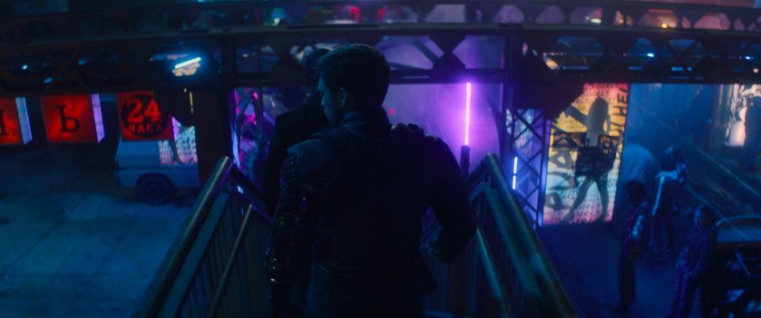 Bucky descends stairs in a crowded courtyard in low-town in Madripoor.