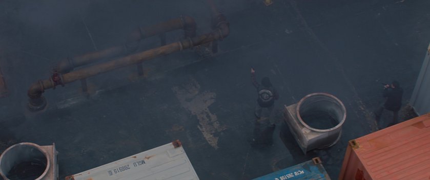Men firing guns in a Madripoor container yard.