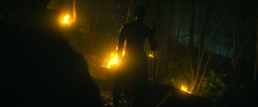 Ayo in a dark, torch-lit Wakandan plateau.