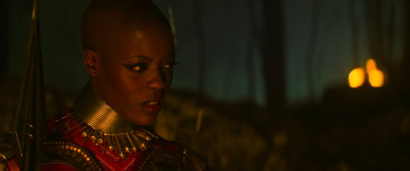 Ayo in a dark, torch-lit Wakandan plateau.