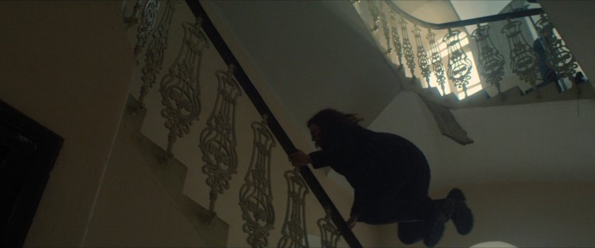 Karli leaping over a stair railing in an old Latvian factory.