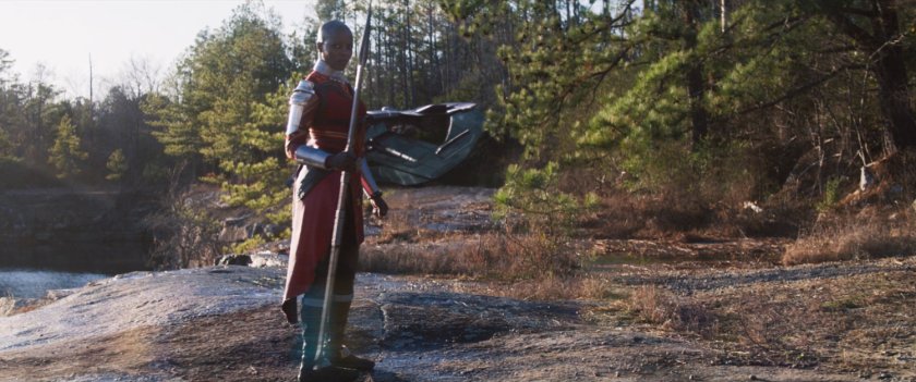 Ayo standing on a rocky hill by a Talon fighter.
