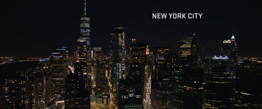 Establishing shot of New York at night. text: New York City.