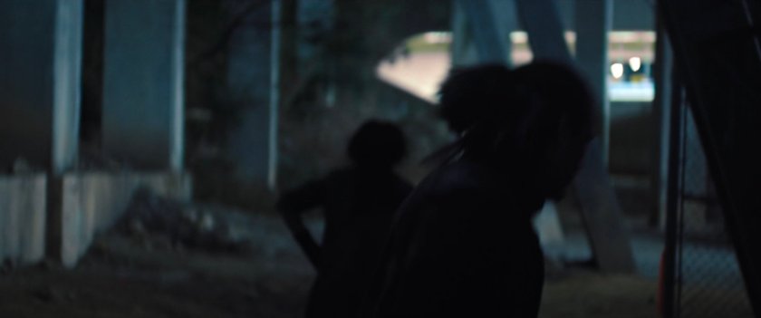 Shadowy people in underground parking structure.