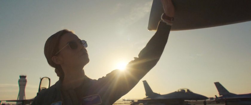 Carol Danvers touches the nose of her fighter plane.