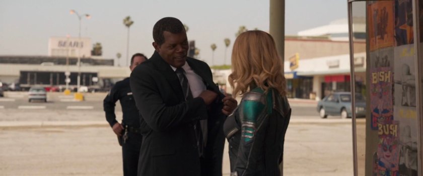 Nick Fury talking to Vers outside a strip mall.