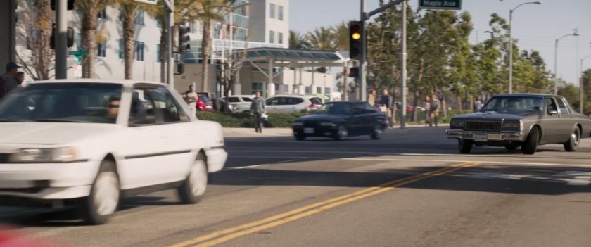Nick Fury's car pursues a metro train on Los Angeles street.