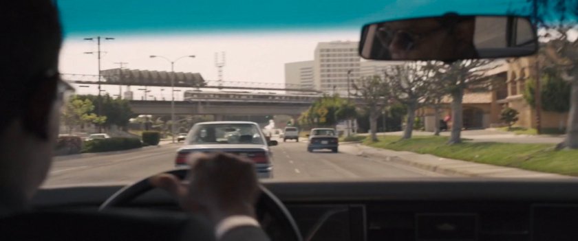 POV of Nick Fury's car racing down Los Angeles street toward Metro overpass.