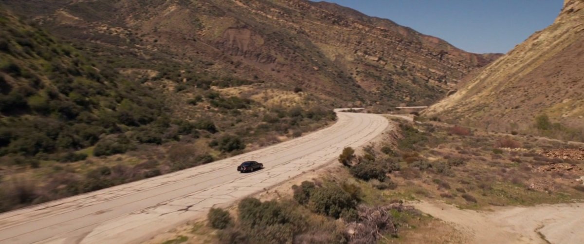 Nicky Fury's car driving up a dusty highway.