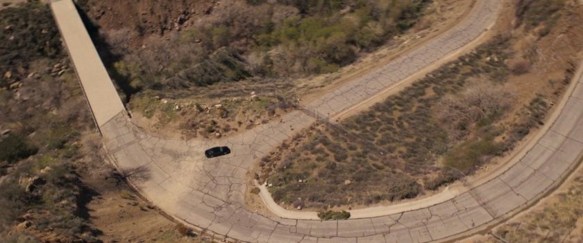 Aerial view of car turning onto deserted road.