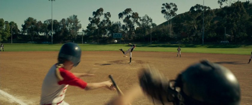 Young Carol Danvers jumps out of the way of a wild baseball pitch.