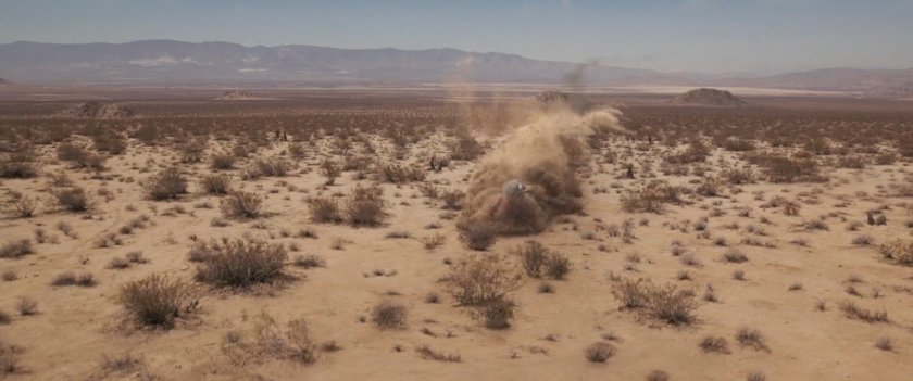 A craft crashes into the sandy desert.