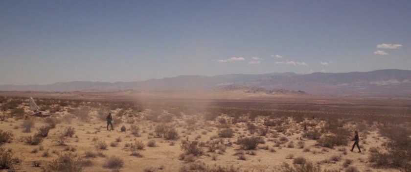 Captain Marvel striding towards Yon-Rogg in the desert.