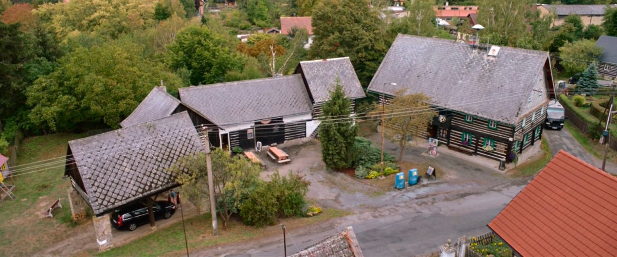 Aerial of small rest stop with wooden buildings.