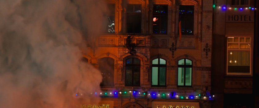 Night Monkey clings to the wall of a Prague Square.