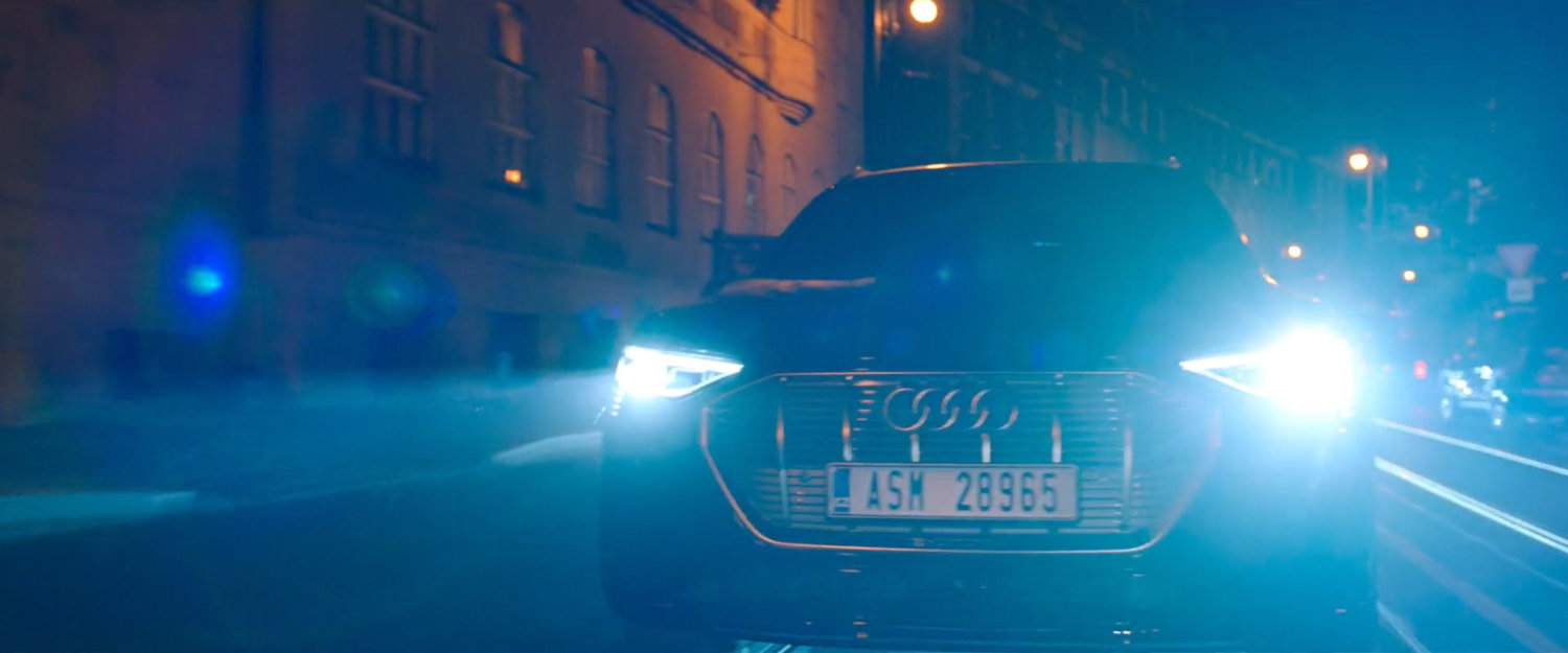A car on a nighttime Prague street. License plate: ASM 28965.