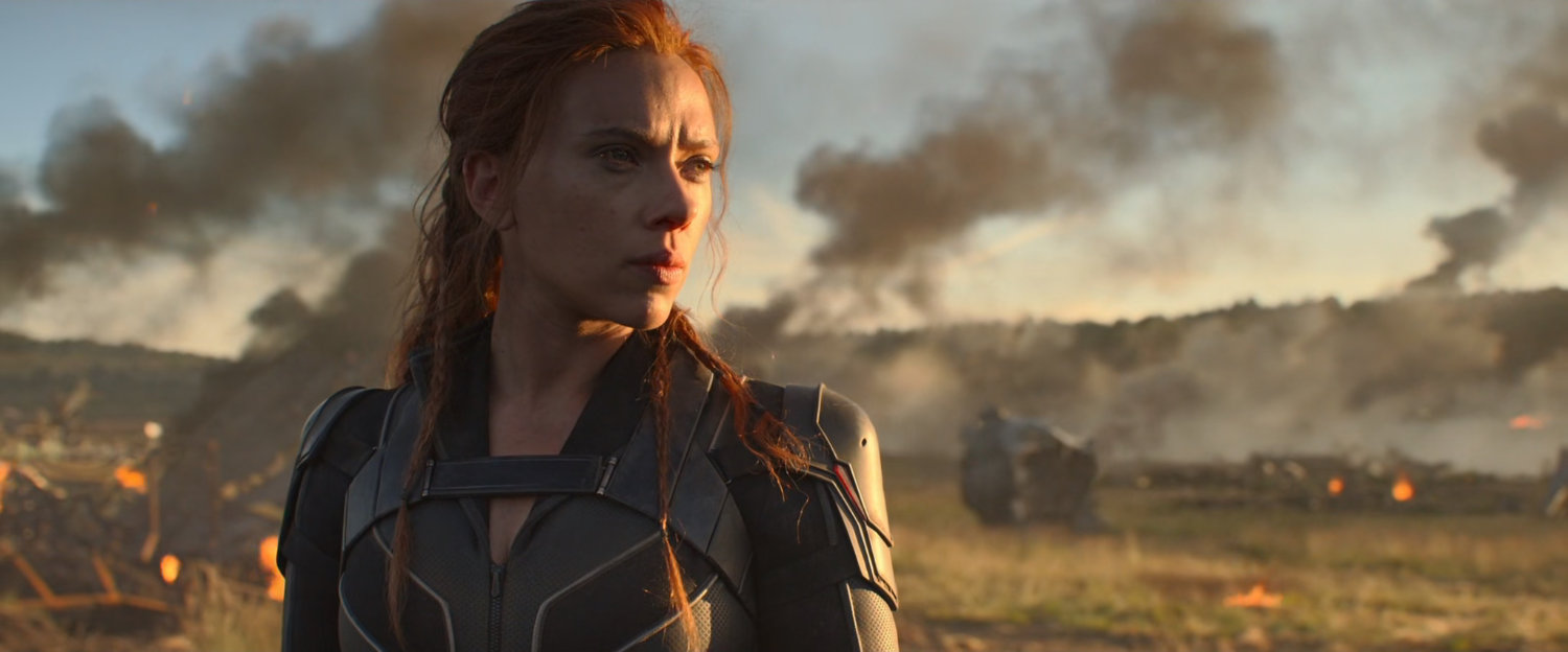 Natasha Romanoff in a field full of burning debris.