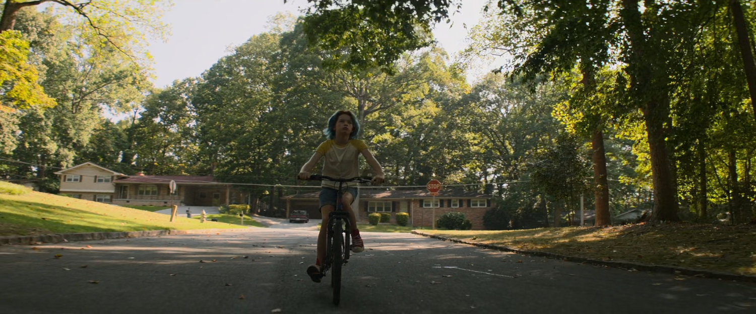 Young Natasha riding bike on suburban street.