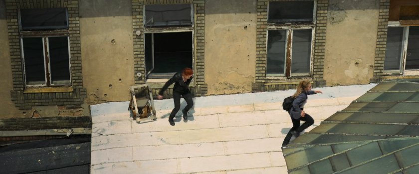 Yelena and Natasha exiting a window onto a Budapest rooftop.