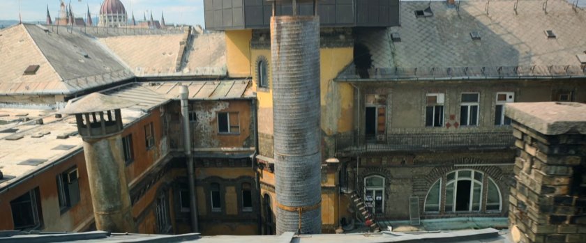 A smokestack in a central courtyard as seen from a Budapest rooftop.