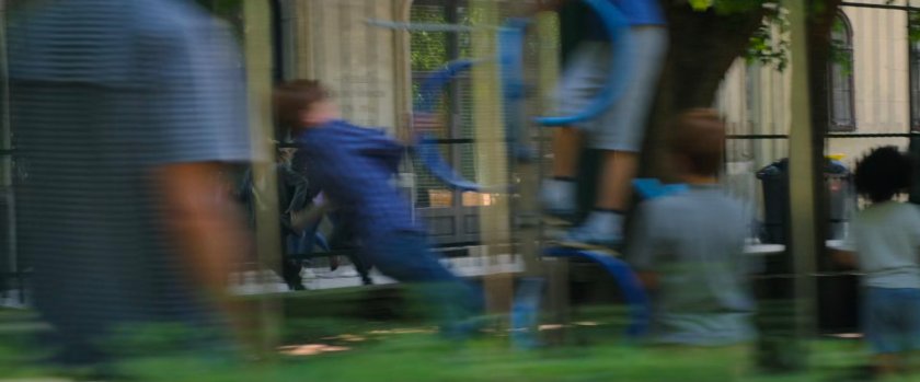 Out of focus playground with Yelena and Natasha running  in background.