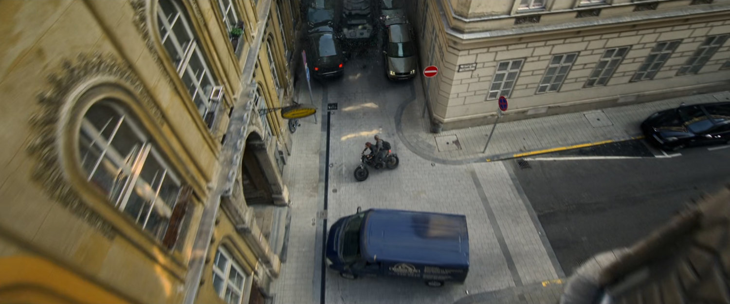 Motorcycle chased down Budapest alley by an APC.