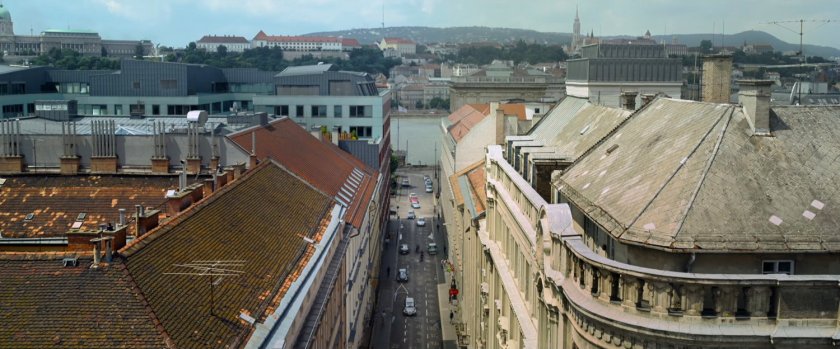 Aerial view of Budapest roofs, street, and river.