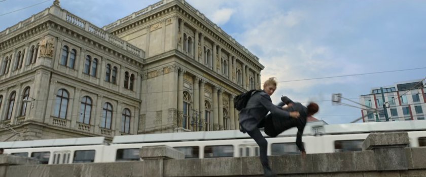 Natasha and Yelena are thrown over a Budapest railing as a tram passes by.