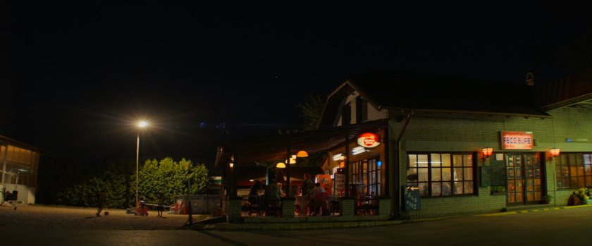 Nighttime view of cafe exterior next to Varoil gas station.