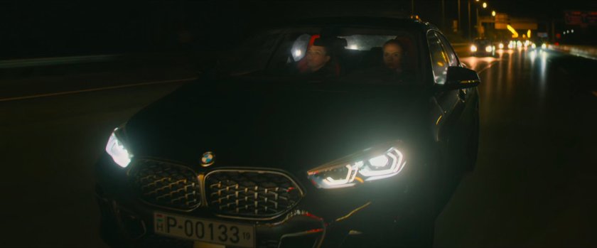 Yelena and Natasha in a car on a Hungary interstate at night.