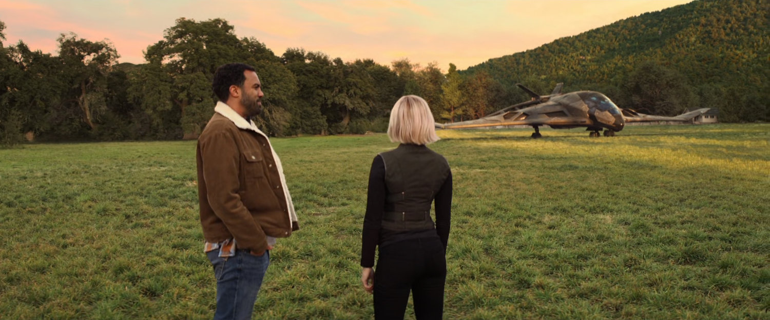 Natasha and Mason in field at magic hour with a quinjet in the background.