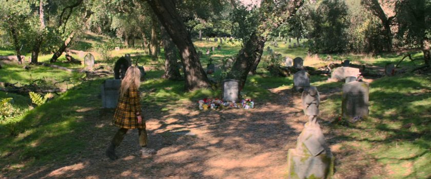 Yelena in a wooded cemetery.