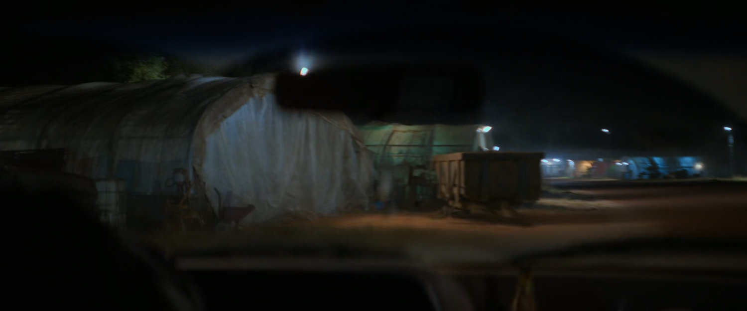 Tarp covered sheds at a small airfield.