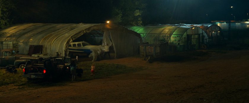 A Cessna inside a small plastic covered shed at a small airfield.