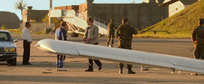 Alexei and Dreykov standing behind Cessna wing on Cuban runway.