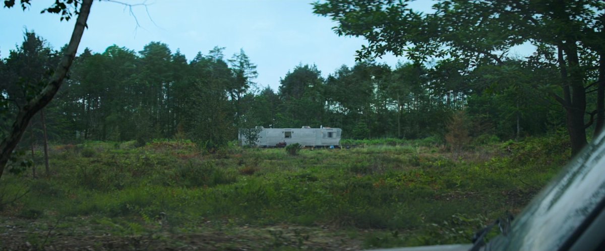 A mobile home in a wooded clearing.